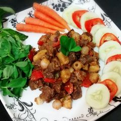 A picture of Beef stew served with fresh veggies.