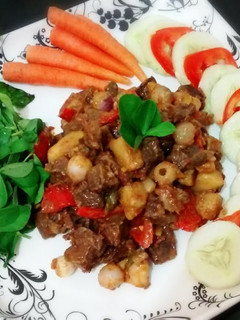 A picture of Beef stew served with fresh veggies.