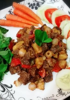 A picture of Beef stew served with fresh veggies.