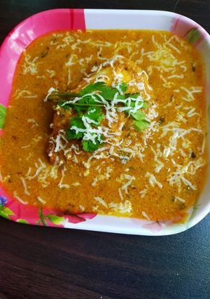 A picture of Stuffed cheese slice with paneer in gravy.