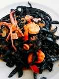 Homemade fresh squid ink pasta with prawns and squid