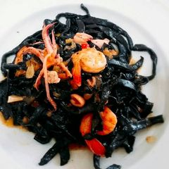 A picture of Homemade fresh squid ink pasta with prawns and squid.