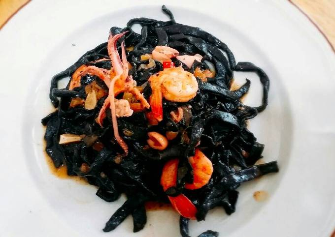 Homemade fresh squid ink pasta with prawns and squid