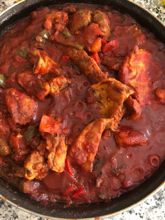 Una foto de Conejo con tomate y pimientos