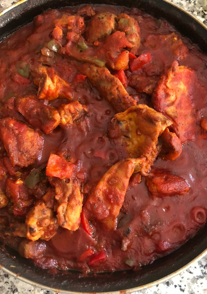 Una foto de Conejo con tomate y pimientos