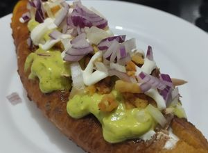 Una foto de Plátano maduro relleno de pollo, chicharrón de cerdo y salsa verde🥯🍖🥑🌮🌯🍗