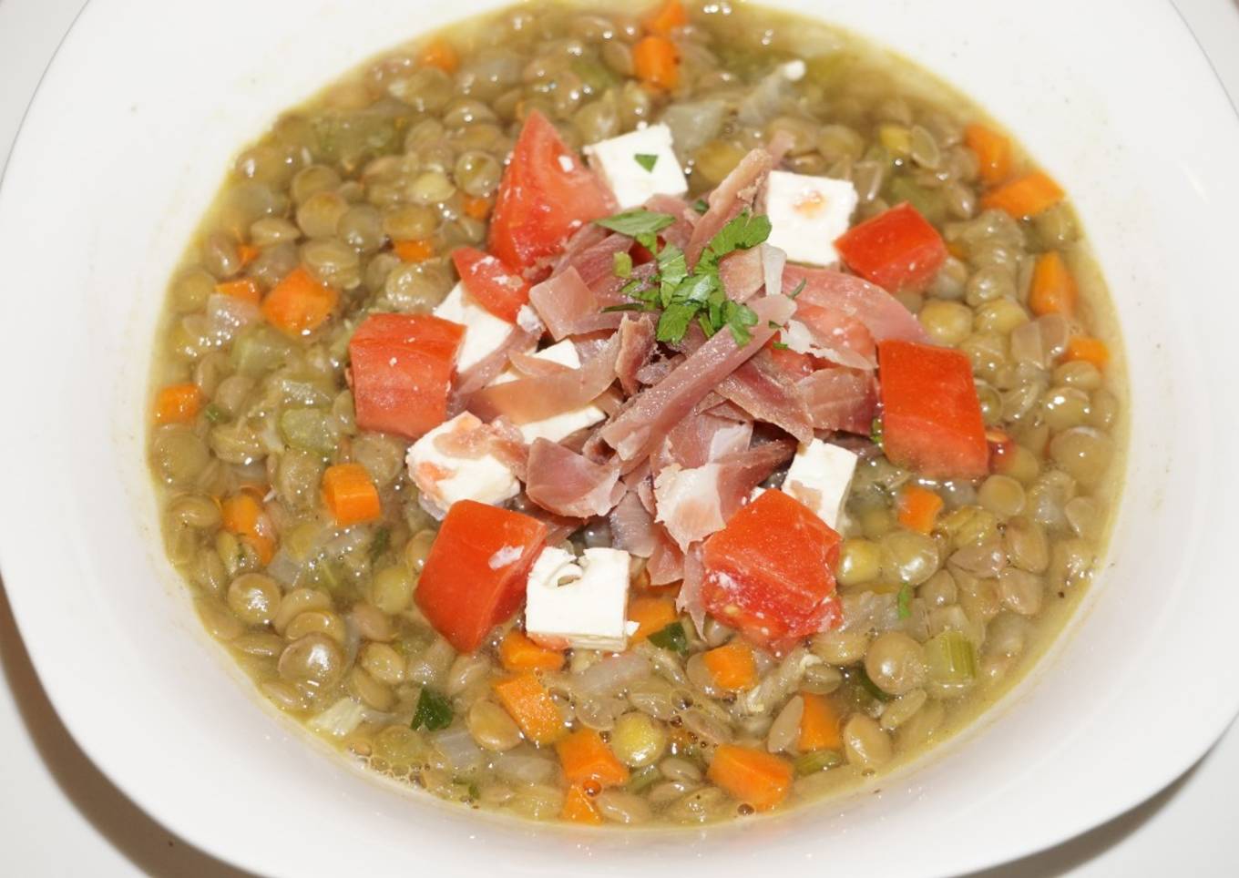 Sopa de lentejas con queso de cabra y jamón curado