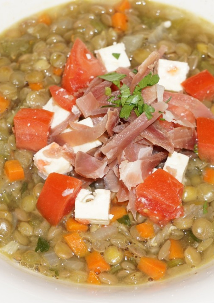Una foto de Sopa de lentejas con queso de cabra y jamón curado
