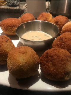Una foto de Bomba de papas rellenas y salsa de verdeo