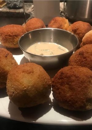 Una foto de Bomba de papas rellenas y salsa de verdeo