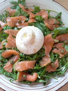 Una foto de Ensalada de salmón y rúcula con burrata