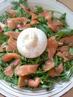 Una foto de Ensalada de salmón y rúcula con burrata