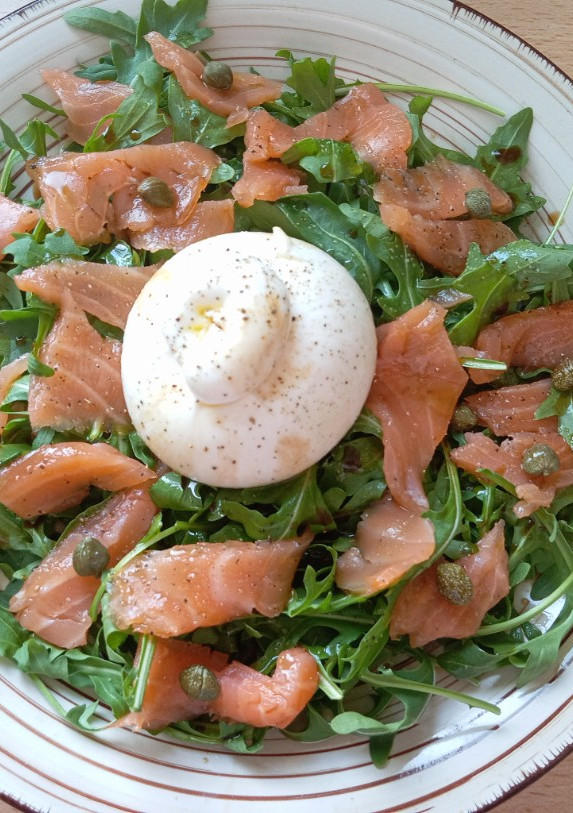 Una foto de Ensalada de salmón y rúcula con burrata