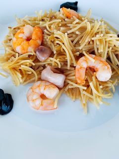 Una foto de Fideuà de calamares con alioli de ajo negro