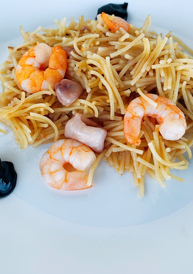 Una foto de Fideuà de calamares con alioli de ajo negro