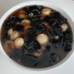A picture of Grass jelly with lychees, tapioca pearls, glutinous rice balls and sago dessert.