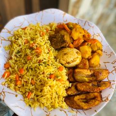 A picture of Fried rice with potato casserole and plantain.