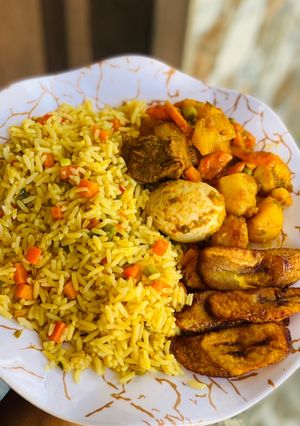A picture of Fried rice with potato casserole and plantain.