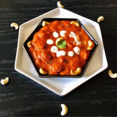 A picture of Kaju Curry in a Red Gravy.