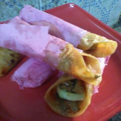 A picture of Tomato kathi roll with butter chicken.