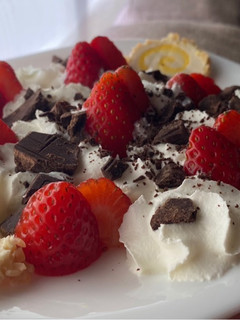Una foto de Postre de Fresas con nata, rulo de queso dulce y chocolate con sal