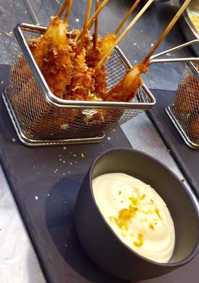 Una foto de Langostinos panko con mantequilla de coliflor y cítricos