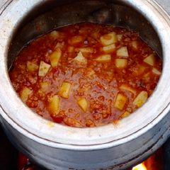 A picture of Desi Keema Alu on wood fire.