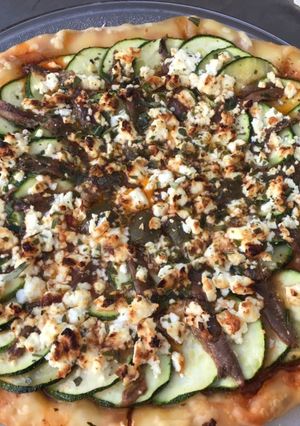 Une photo de Pizza courgettes tomates aubergines feta anchois câpres italiennes