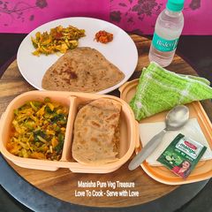 A picture of Triangle Jeera Paratha - Cabbage, Potato, Peas, Tomato Dry Sabzi - Packed In Bento Box.