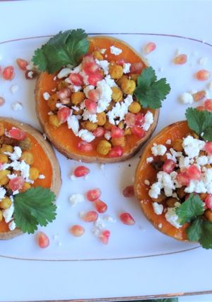 Una foto de Calabaza asada con garbanzos crujientes, queso feta y granada