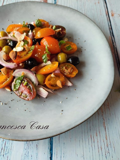 Foto di Insalata di pomodorini gialli, olive, cipolla e mandorle