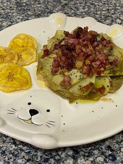 Una foto de Flor de alcachofa con sal negra, con crujiente de jamón y chips de plátano