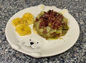 Una foto de Flor de alcachofa con sal negra, con crujiente de jamón y chips de plátano
