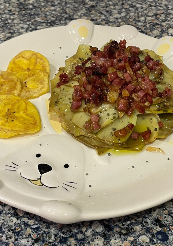 Una foto de Flor de alcachofa con sal negra, con crujiente de jamón y chips de plátano