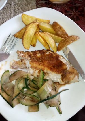 A picture of Deep fried potato wedges with pan fried red snapper and cucumber in balsamic vinegar.