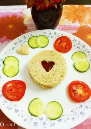 A picture of Whole grain bread with tomato ketchup and tomato,cucumber slices.