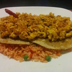 A picture of Scrambled rancheros' eggs over rice.