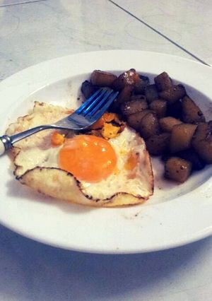 A picture of Spiced potatoes and sunnyside eggs.