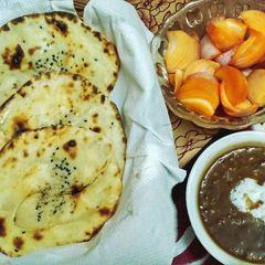 A picture of Tandoori naan with dal makhani and sirke wale pyaj.