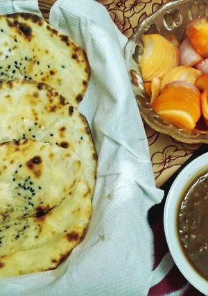 A picture of Tandoori naan with dal makhani and sirke wale pyaj.