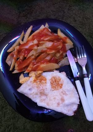 A picture of French fries with fried eggs.