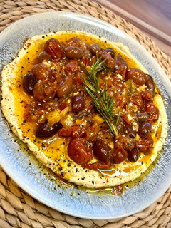 Una foto de Cherrys confitados sobre hummus