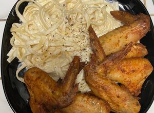 Una foto de Fettuccini Alfredo, con alitas de pollo en la freidora de aire
