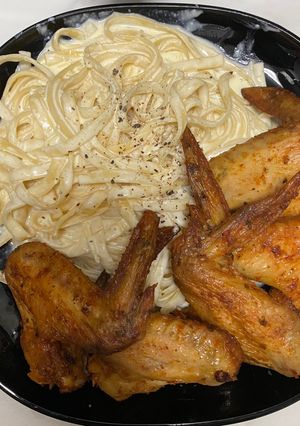 Una foto de Fettuccini Alfredo, con alitas de pollo en la freidora de aire