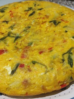 Una foto de Tortilla de patatas con pimientos rojos y collejas