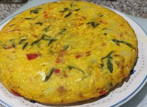 Una foto de Tortilla de patatas con pimientos rojos y collejas