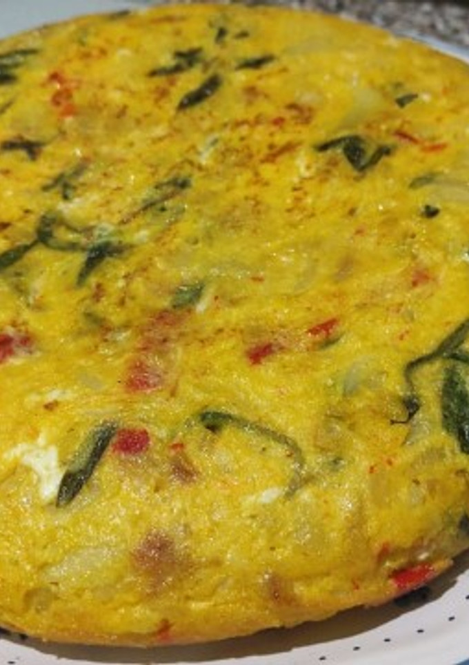 Una foto de Tortilla de patatas con pimientos rojos y collejas