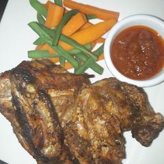 A picture of Grilled chicken with carrots and green peas.