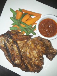 A picture of Grilled chicken with carrots and green peas.