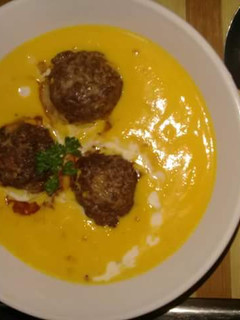 A picture of Creamy pumpkin soup and meatballs.